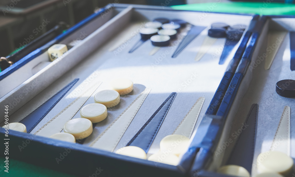 Playing Backgammon. Close view of the board and pieces of two colors. Table games concept. Playing Backgammon. Close view of the board and pieces of two colors. Table games concept.