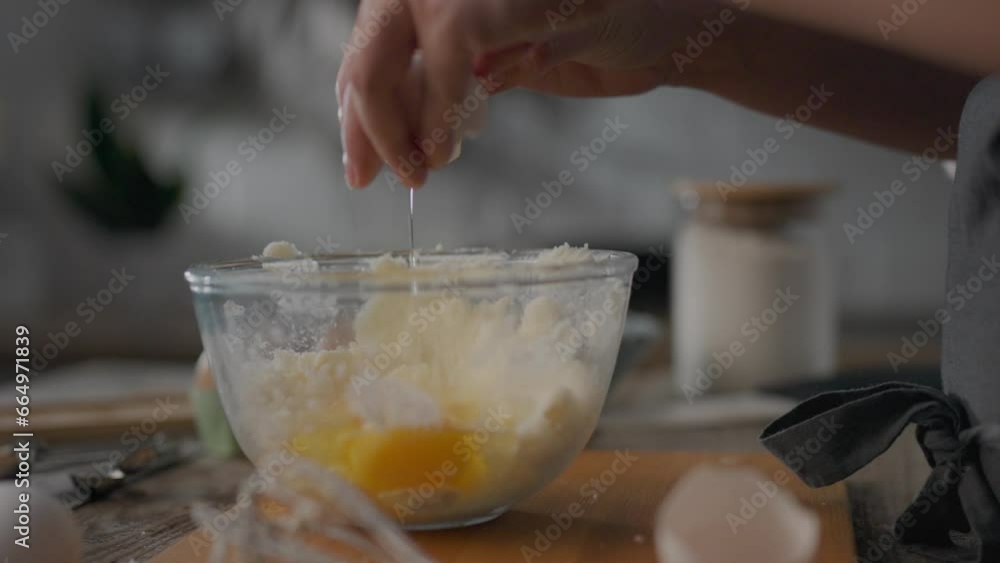 Young woman is cracking fresh eggs, dripping them into a glass bowl with other ingredients for pie. Preparing raw ingredients for healthy homemade baking. Slowly breaking the eggshells. Home kitchen
Young woman is cracking fresh eggs, dripping them into a glass bowl with other ingredients for pie. Preparing raw ingredients for healthy homemade baking. Slowly breaking the eggshells. Home kitchen