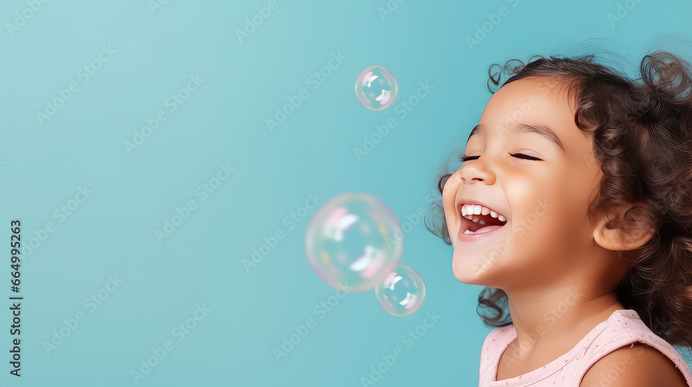 Close-up of a cheerful happy child blowing soap bubbles on a flat color background with copy space. Kindergarten and children activities banner template. Close-up of a cheerful happy child blowing soap bubbles on a flat color background with copy space. Kindergarten and children activities banner template.