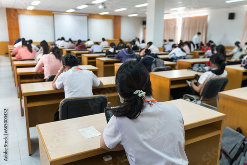 Selective focus high school or university students concentrate on language listening test in the examination hall