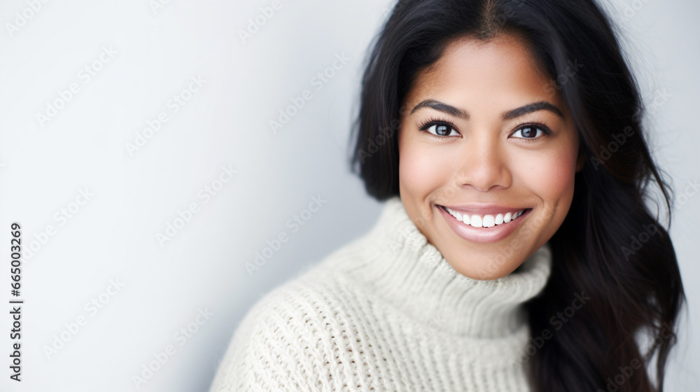 Young Hispanic woman with a genuine, warm smile poses for a portrait in an elegant white setting, creating a cheerful and inviting atmosphere. Young Hispanic woman with a genuine, warm smile poses for a portrait in an elegant white setting, creating a cheerful and inviting atmosphere.
