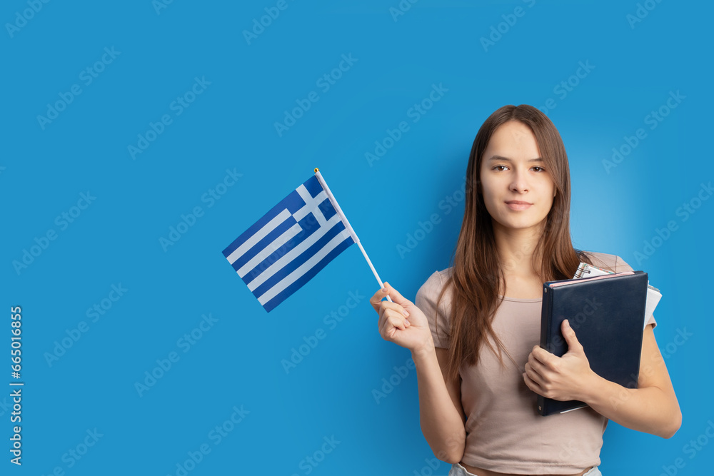 student with Greek flag on blue background, language learning, immigration, foreign education, work abroad, copy space student with Greek flag on blue background, language learning, immigration, foreign education, work abroad, copy space