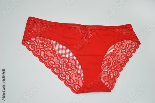 Lingerie. Bright red panties with lace on a white background. Sexy colored women's fashion underwear.