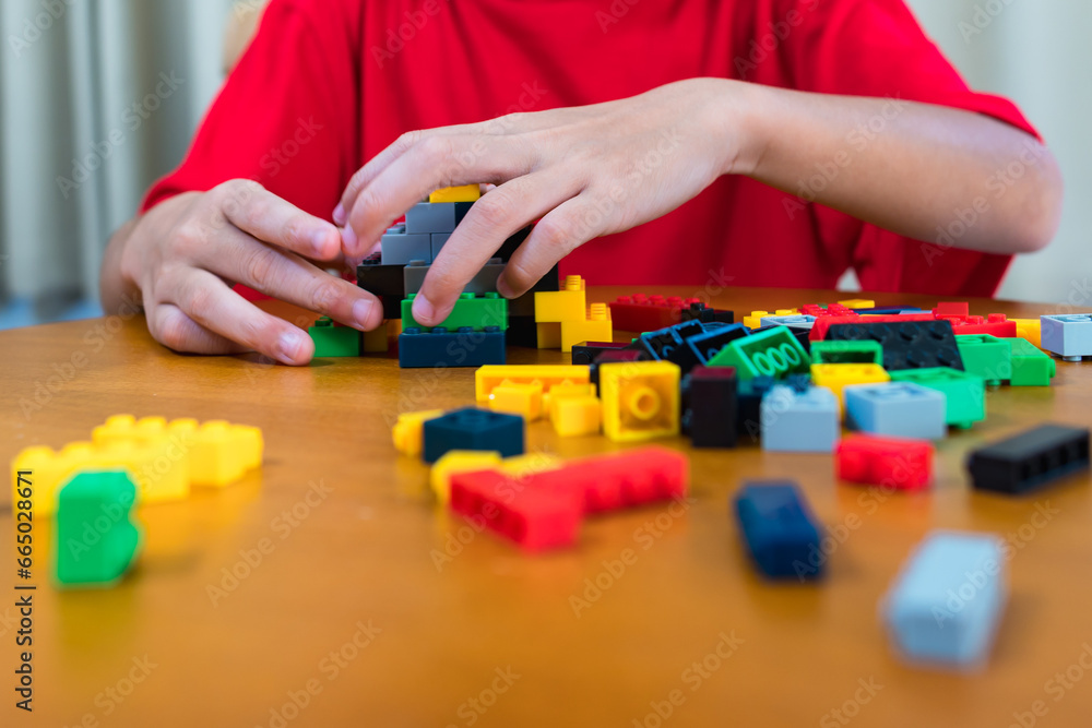 Child playing with colored blocks at home Children play and create shapes according to their imagination, develop creativity, develop children's small muscles. Child playing with colored blocks at home Children play and create shapes according to their imagination, develop creativity, develop children's small muscles.