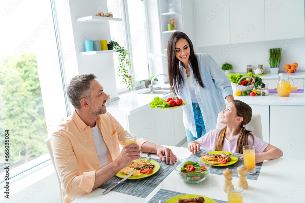 Portrait of family harmony cheerful parents adorable daughter enjoy homemade food chatting free time house indoors