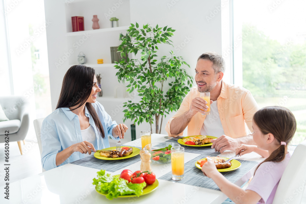 Portrait of cheerful satisfied people sit dining room table enjoy homemade healthy food drink juice communicate house inside Portrait of cheerful satisfied people sit dining room table enjoy homemade healthy food drink juice communicate house inside