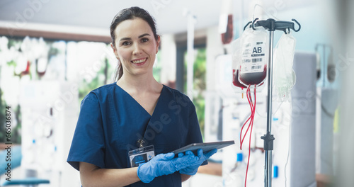 Tableau sur toile Female Nurse Holding Tablet Computer And Checking The Blood Bag In Donation Center
