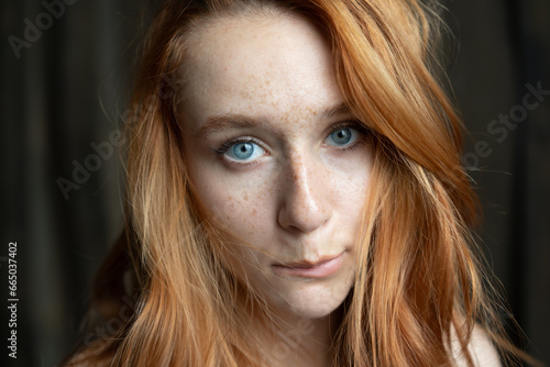 Portrait of a young beautiful woman with red hair in studio