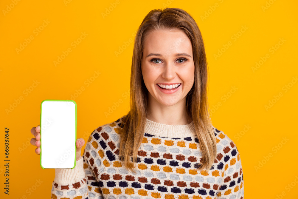 Closeup photo of young cheerful smile lady hold smartphone display empty space isolated on yellow color background Closeup photo of young cheerful smile lady hold smartphone display empty space isolated on yellow color background