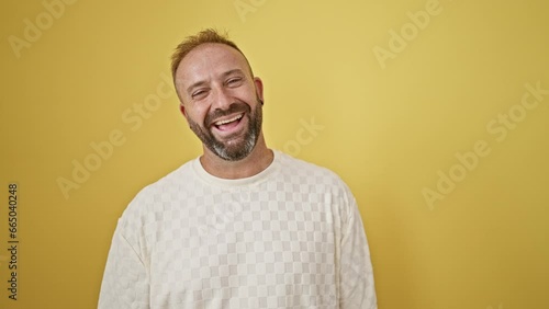 Young man laughing a lot over isolated yellow background