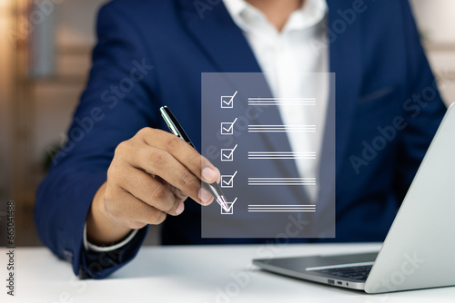 Digital Checklists for efficient business management, Businessman touching marking on checklist guide to paperless assessment and Future Success, Streamlining operations with online surveys. photo