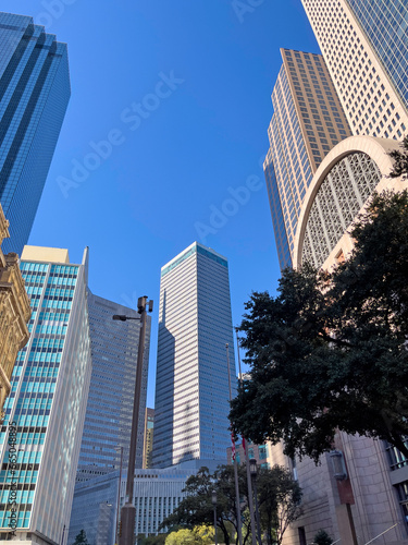 A skyline street view of Dallas Texas. These glass skyscrapers in the Texas lone star state on a clear blue sky day. 