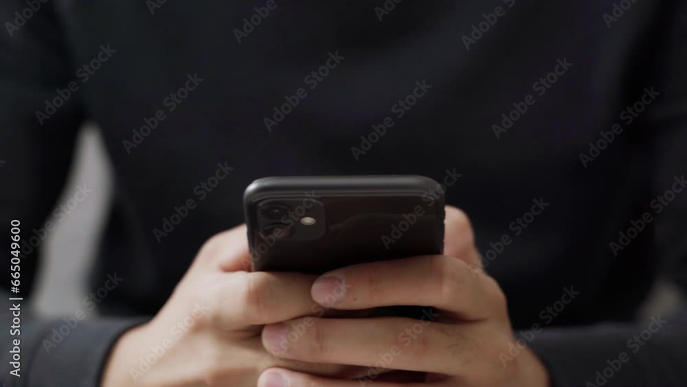 The young man's hand is using a smartphone to access the internet and searching for information, social network. The young man's hand is using a smartphone to access the internet and searching for information, social network.
