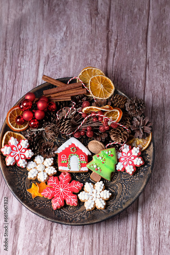 Christmas holiday background. Plate with Homemade Christmas gingerbread cookies and decor on wooden table. New Year, Christmas holidays concept. festive winter season. top view.