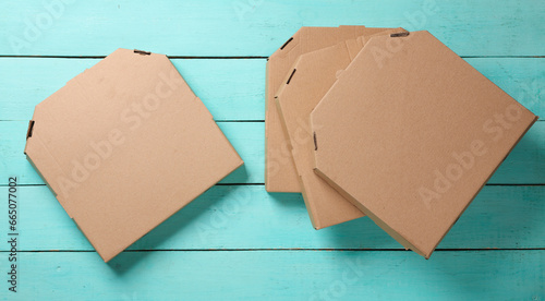 Cardboard craft pizza boxes on blue wooden background. Top view.