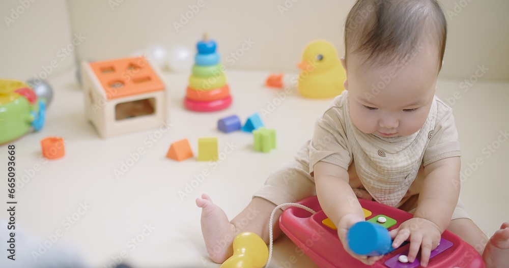 Portrait Of Adorable Happy little Asian baby child Toddler playing with colorful toy on floor living room, Educational game for baby and toddler Portrait Of Adorable Happy little Asian baby child Toddler playing with colorful toy on floor living room, Educational game for baby and toddler