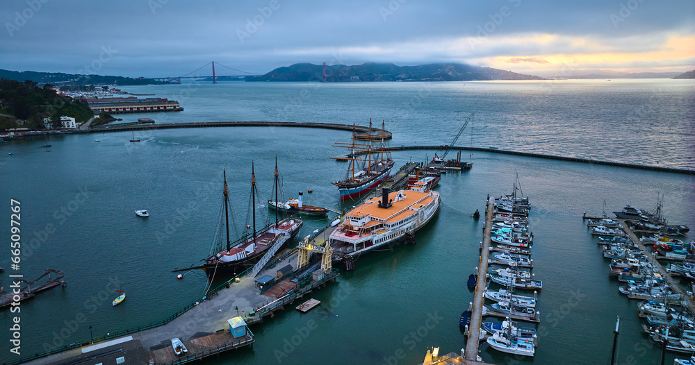 Hyde St Pier at dusk with golden edge on horizon ships in the harbor aerial