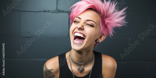 Stylish woman with pink hair and piercings laughing by black wall. photo