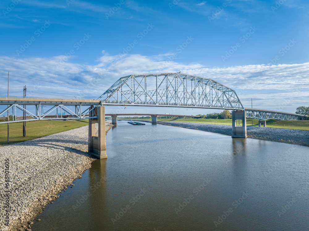 Obraz premium bridges and towboats with barges on Chain of Rock Bypass Canal of Mississippi River above St Louis, aerial view in October scenery