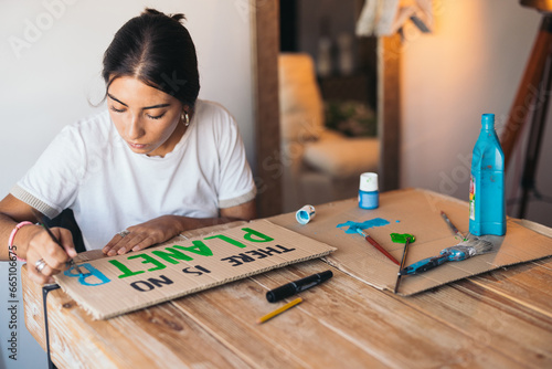 Woman painting a poster about the environment photo