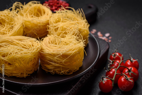 Raw capellini pasta or noodles with salt and spices
