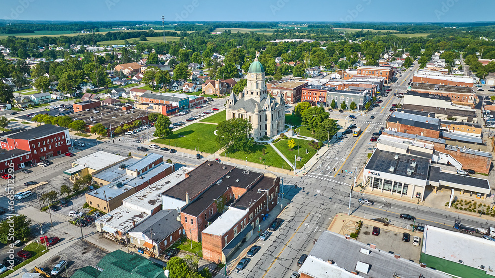 Aerial over downtown Columbia City with courthouse in center surrounded by shops and houses