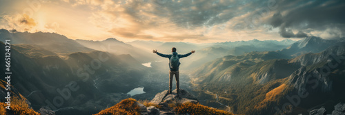 Traveler standing on top of a mountain with hands raised up , mission success and goal achieved, active tourism and mountain travel photo