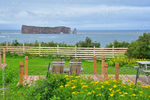 Adirondack chairs on terrace with view on Percé Rock huge sheer rock formation in the Gulf of Saint Lawrence on the tip of the Gaspé Peninsula in Québec, Canada photo