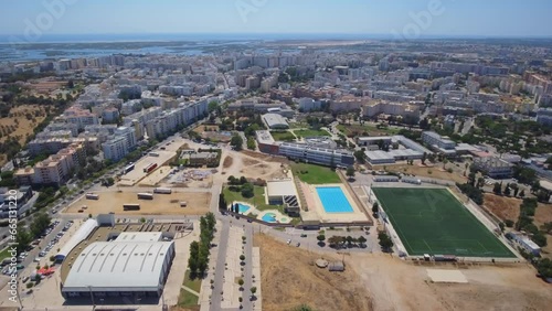 Drone video footage over the Portuguese city of Faro over a sports complex, stadium and university.