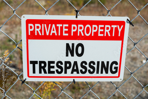 private property no trespassing sign tied to a metal fence photo