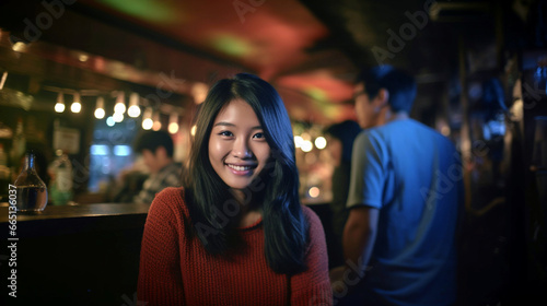 Asian woman smiles in dimly lit bar, joyful atmosphere.