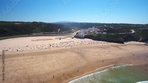 Aerial video filming by drone of the sea bay and beach near village of Odeceixe Alentejo Portugal. Tourists on the beach and in the water.