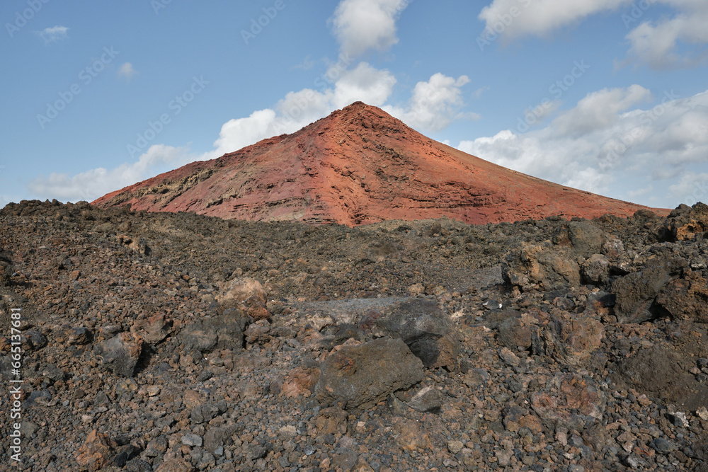 View of a dormant volcano with lava flow in the foreground on Lanzarote, Canary Islands, Spain. 