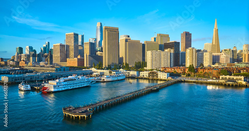Aerial Pier 7 at sunrise with San Francisco skyscraper skyline and boats docked in bay