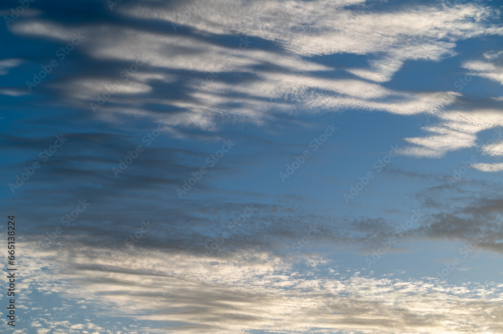 Obraz premium Background of a blue sky with beautiful cirrus clouds at sunset