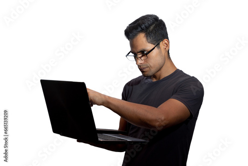 Young Latino with glasses and a laptop, looking at and pointing to the computer screen. Networking concept, programming, business, cybersecurity. Isolated.