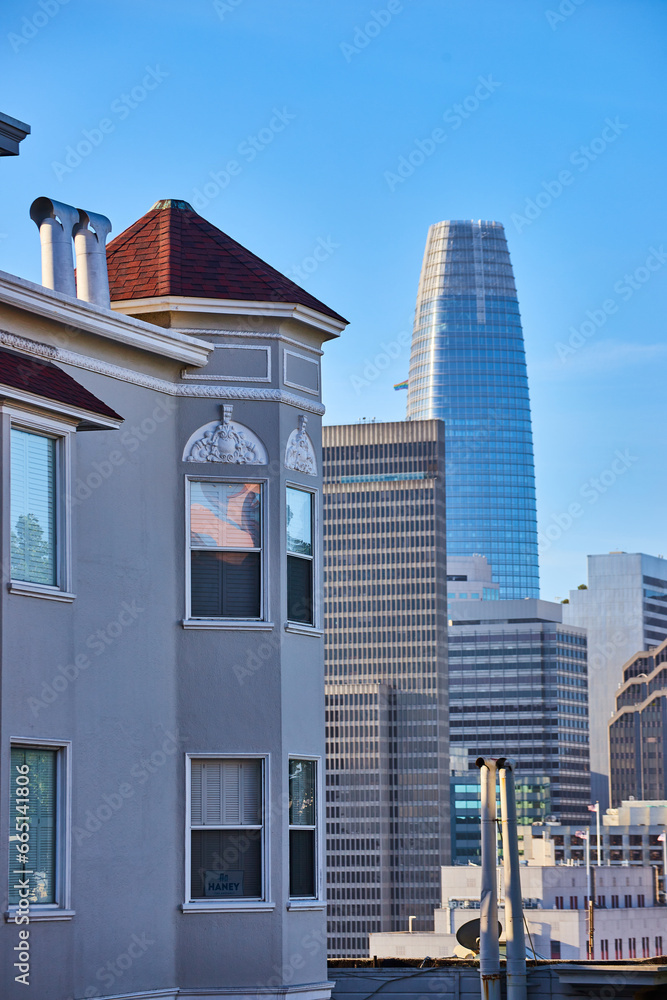 Apartment and skyscraper buildings leading to Salesforce Tower on blue sky day