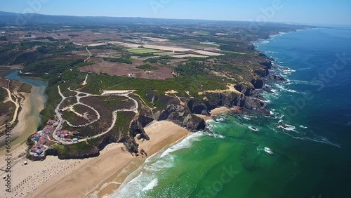 Aerial video filming by drone of the sea bay and beach near the village of Odeceixe Alentejo Portugal. Top view of bay and village