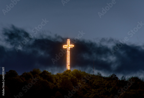 clouds and illuminated cross in the evening at sunset