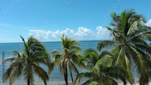 ascending aerial footage of a beautiful summer landscape at Hobie Island Beach Park with blue ocean water, people relaxing in the sand and swimming, palm trees, blue sky and clouds in Miami Florida photo