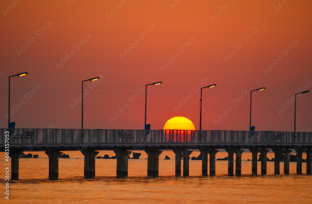 sunrise with pontoon in summer at sea