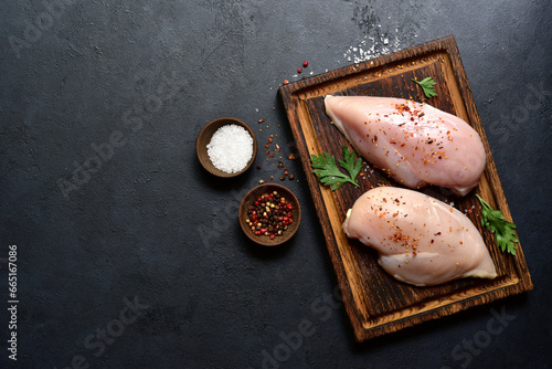 Raw organic chiken breasts with ingredients for making. Top view with copy space. photo