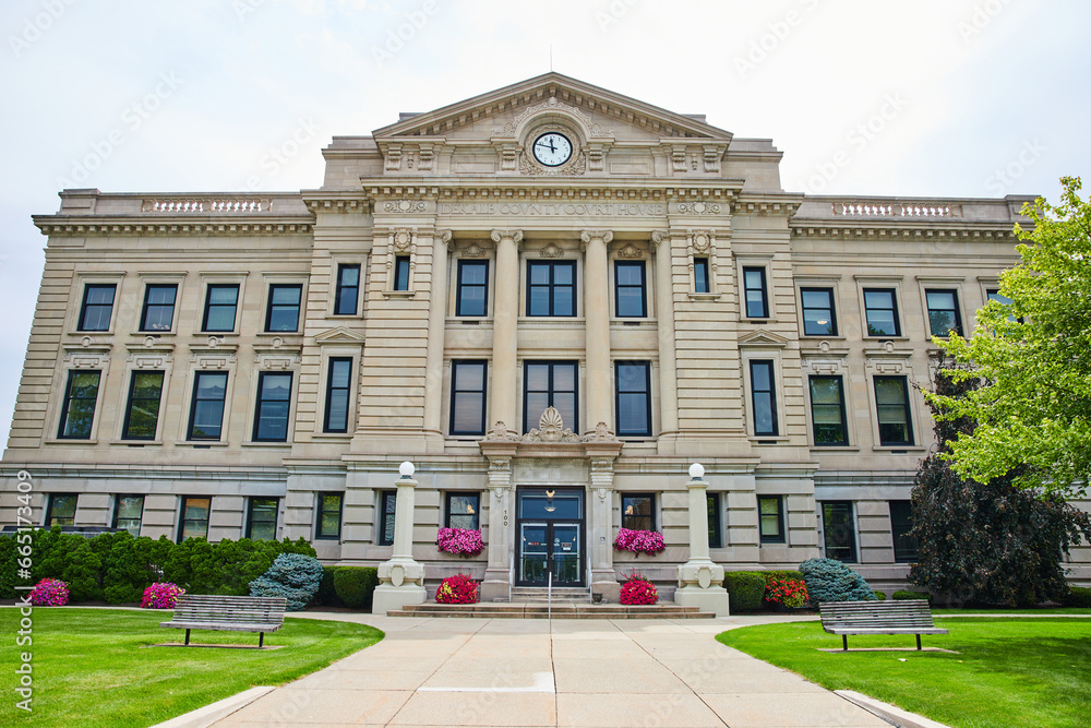 Entrance to Dekalb County Court House with flowers around entrance and benches on green lawn