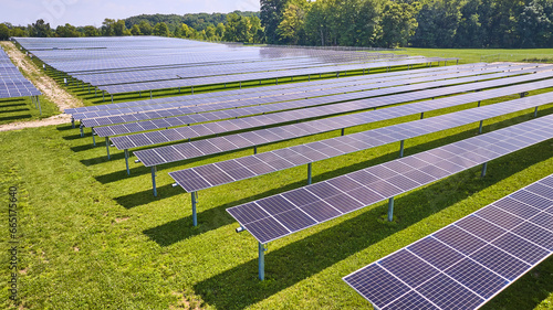Horizontal rows of solar panels on farm on sunny summer day in Midwest aerial