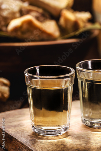 Cachaça, pinga, cana or caninha is the sugar cane brandy, a typical drink from Brazil, with a crackling appetizer in the background