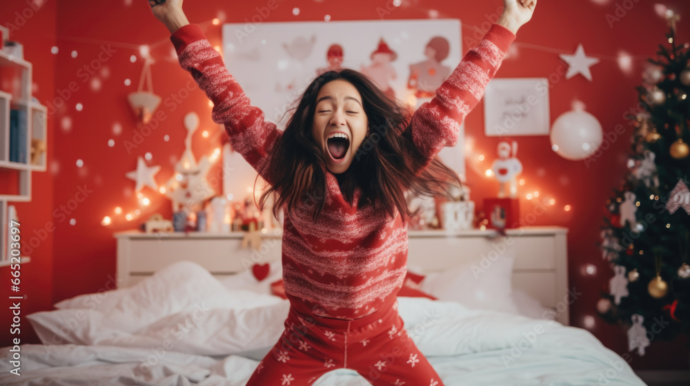 Young happy woman in red christmas pajama in her decorated bedroom. Young happy woman in red christmas pajama in her decorated bedroom.