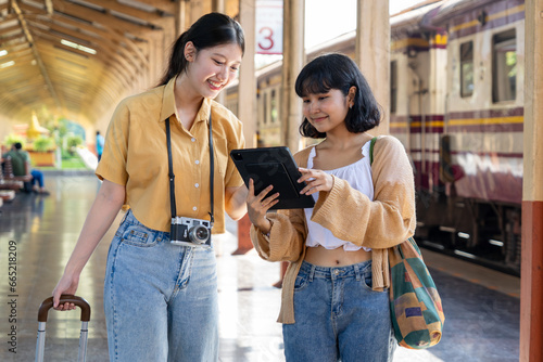 Woman checking map on phone with backpack, travel by train, destination nature trip in summer photo