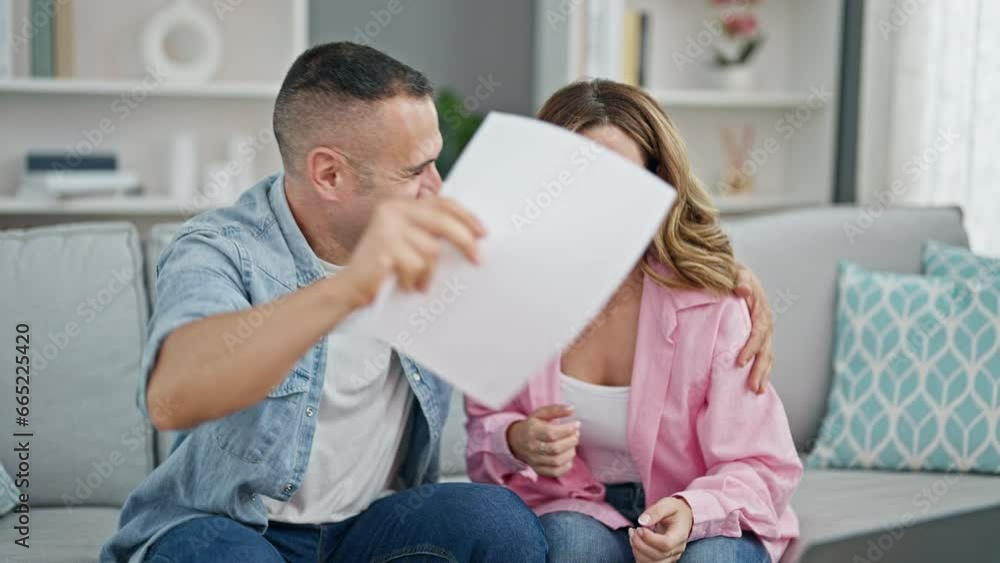 Man and woman couple reading document celebrating at home Man and woman couple reading document celebrating at home