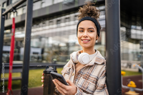 One young sporty woman with headphones use mobile phone app for music