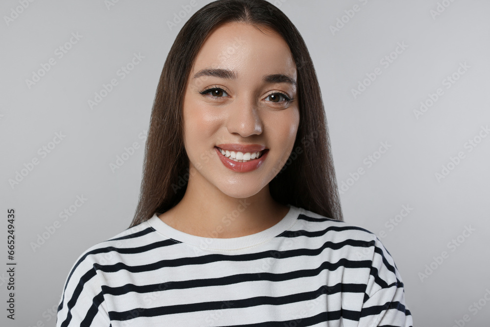 Portrait of beautiful young woman on light grey background Portrait of beautiful young woman on light grey background